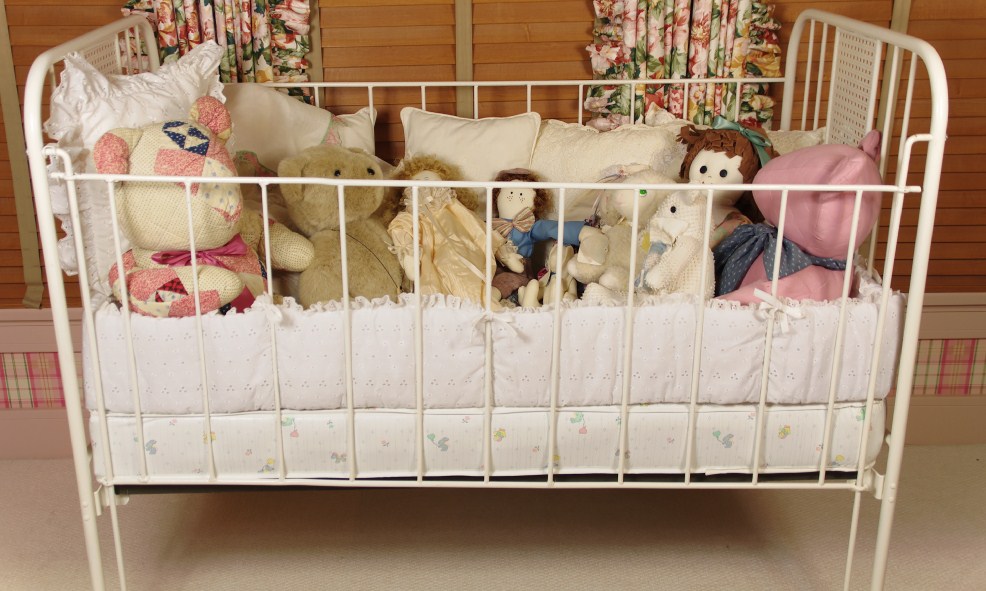 Cast Iron Crib, circa 1940-50, filled with Dolls, Bunnies, and Lace Pillows