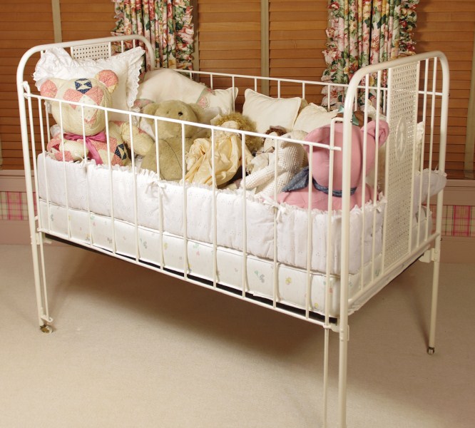 Cast Iron Crib, circa 1940-50, filled with Dolls, Bunnies, and Lace Pillows