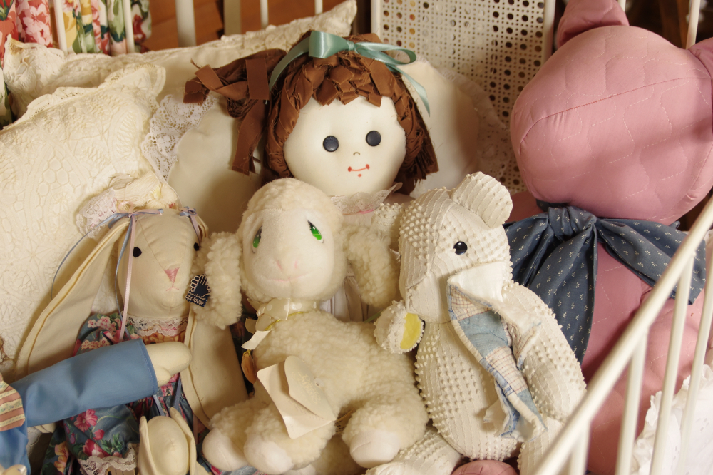 Cast Iron Crib, circa 1940-50, filled with Dolls, Bunnies, and Lace Pillows
