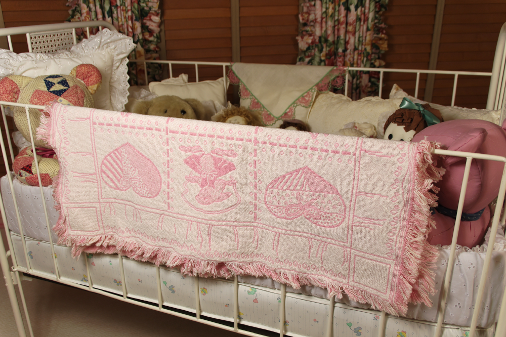 Cast Iron Crib, circa 1940-50, filled with Dolls, Bunnies, and Lace Pillows