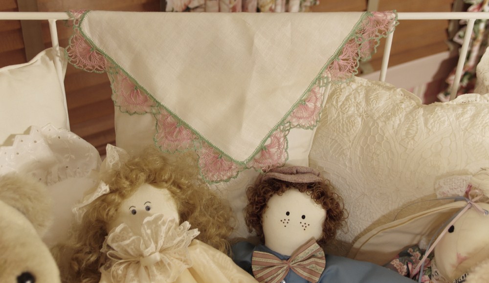 Cast Iron Crib, circa 1940-50, filled with Dolls, Bunnies, and Lace Pillows