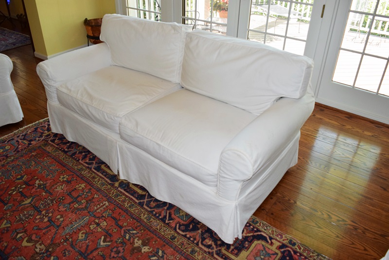 An Arhaus Two Cushion Sofa with White Canvas Slipcover