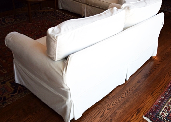 An Arhaus Two Cushion Sofa with White Canvas Slipcover