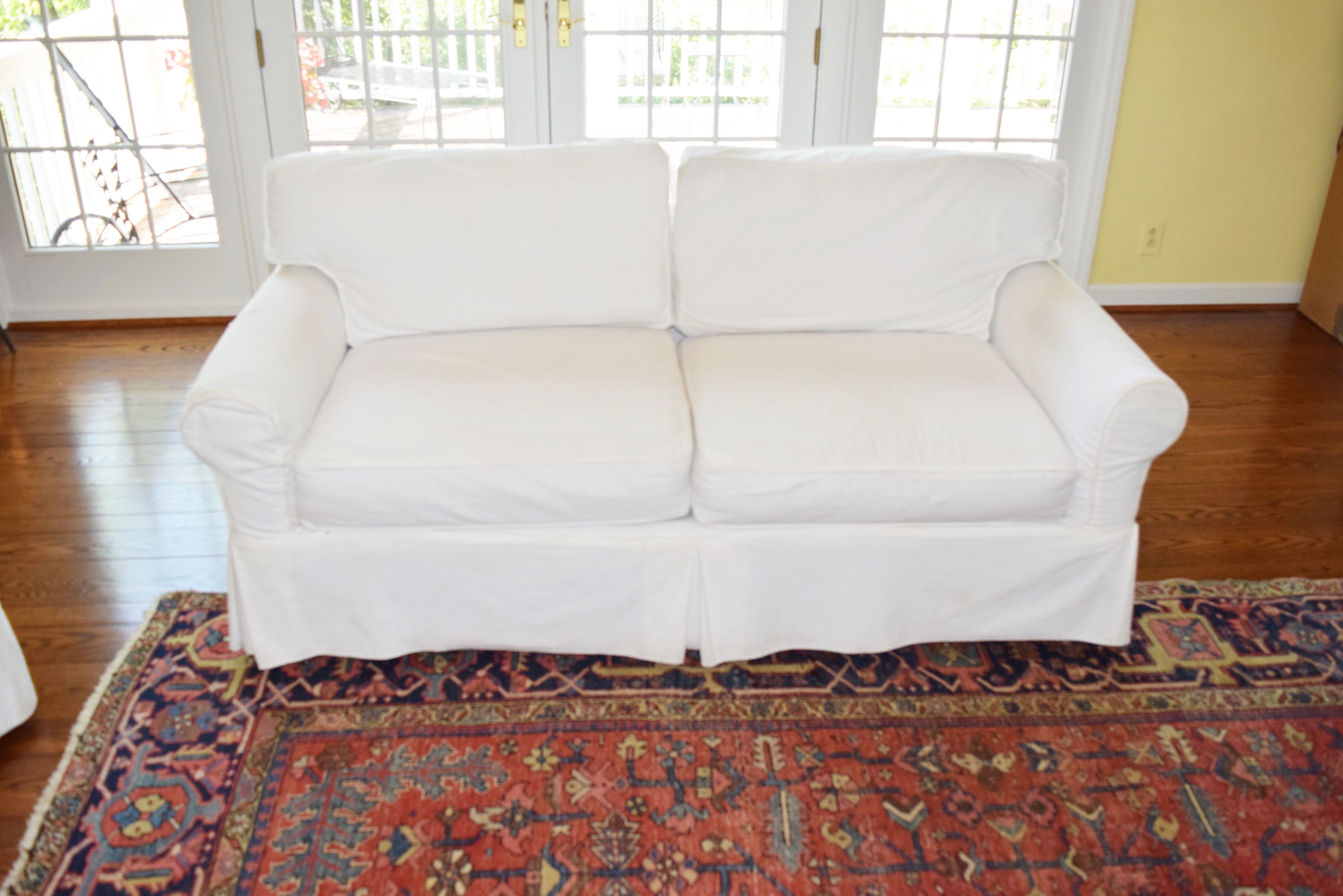 An Arhaus Two Cushion Sofa with White Canvas Slipcover