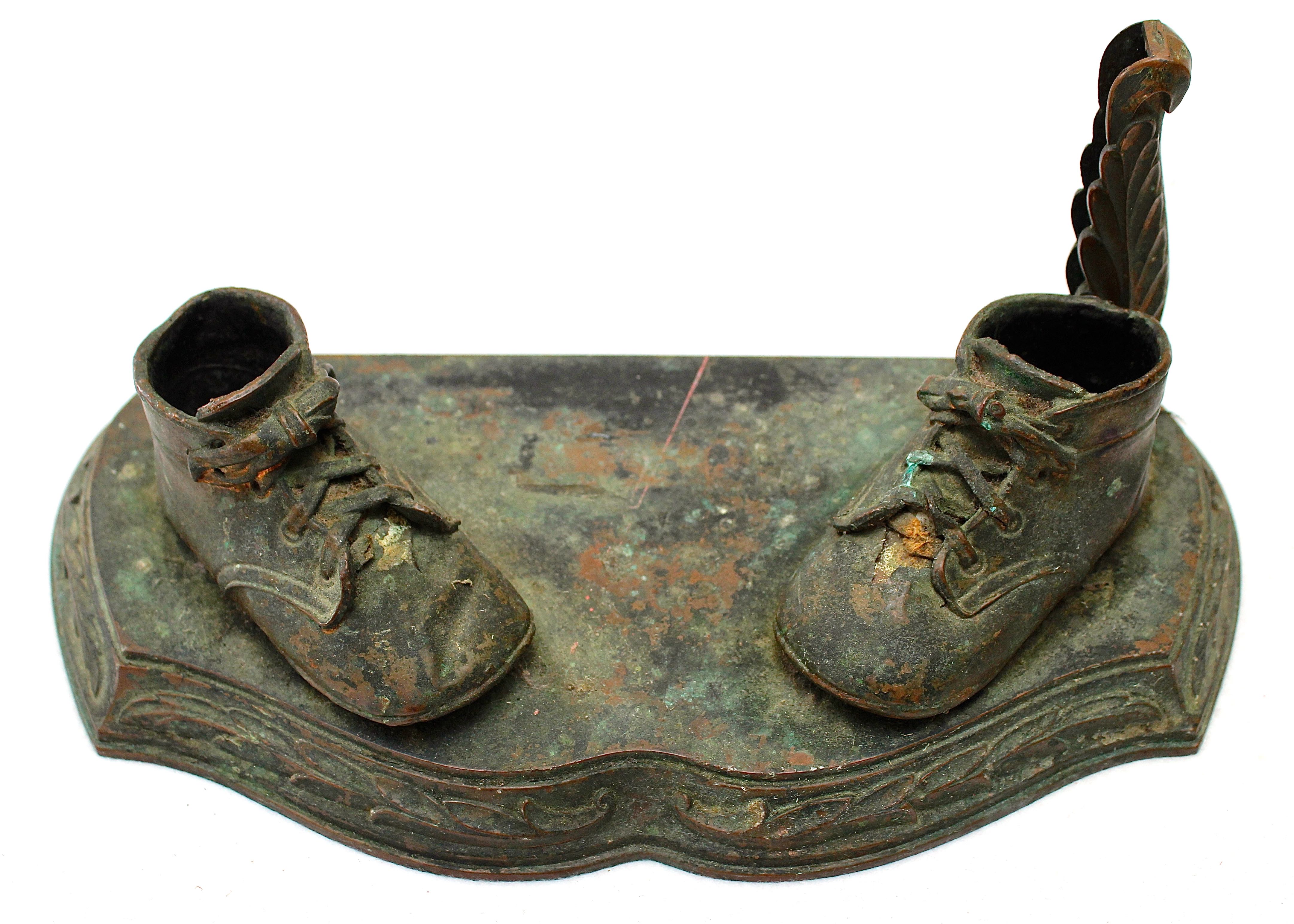 Pair of Vintage Distressed Bronze Look Baby Shoes on a Plinth