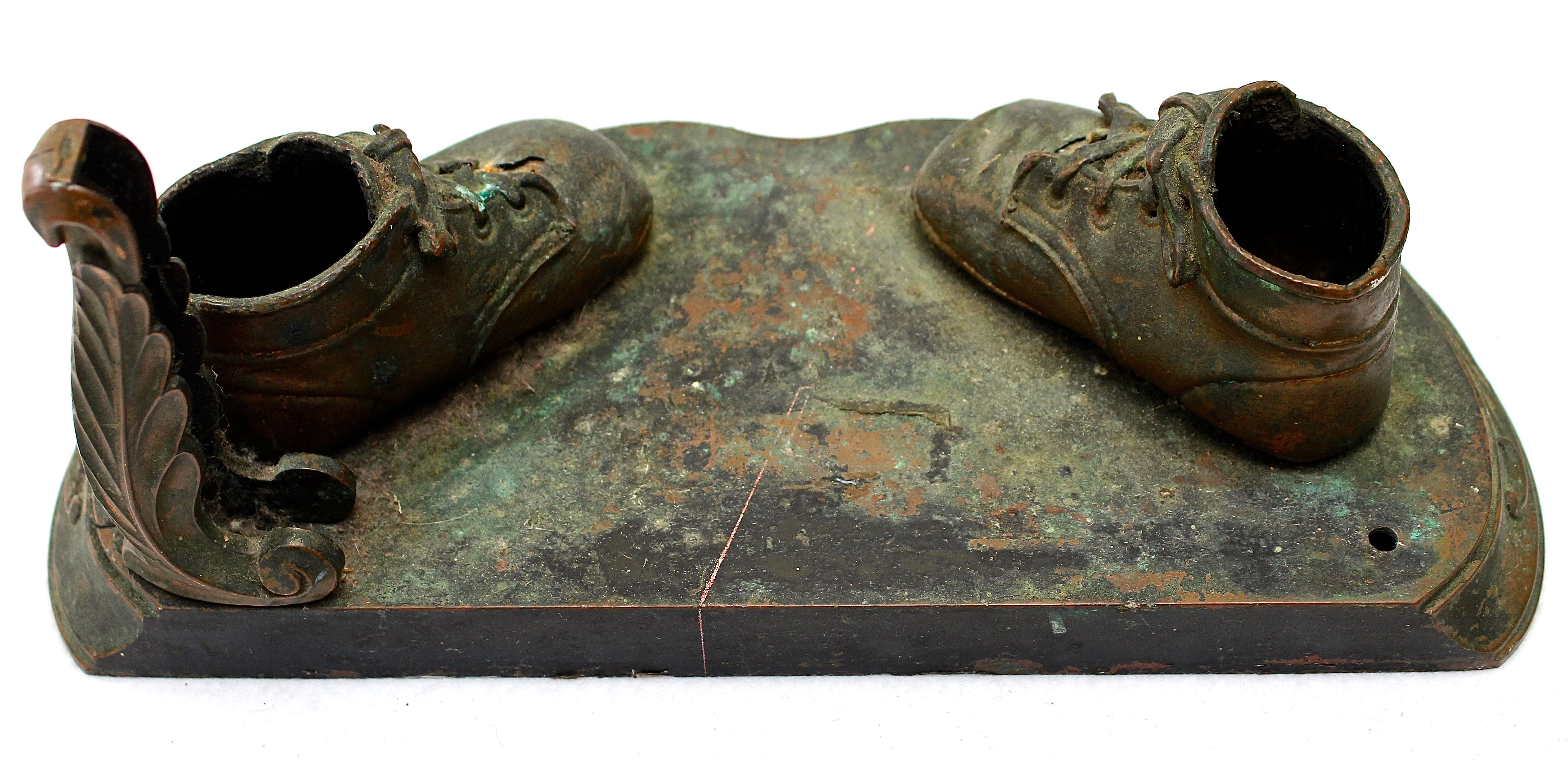 Pair of Vintage Distressed Bronze Look Baby Shoes on a Plinth