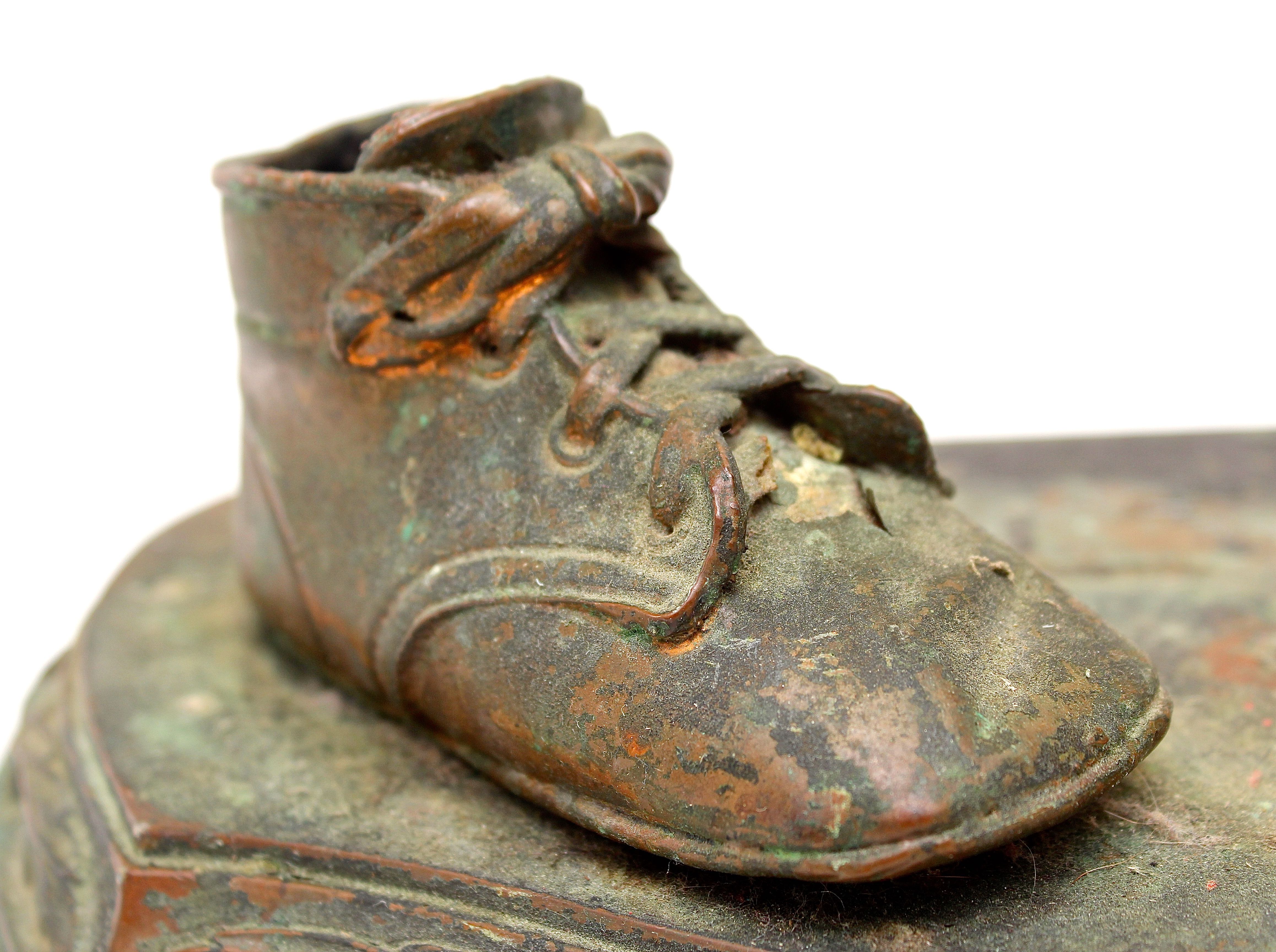 Pair of Vintage Distressed Bronze Look Baby Shoes on a Plinth
