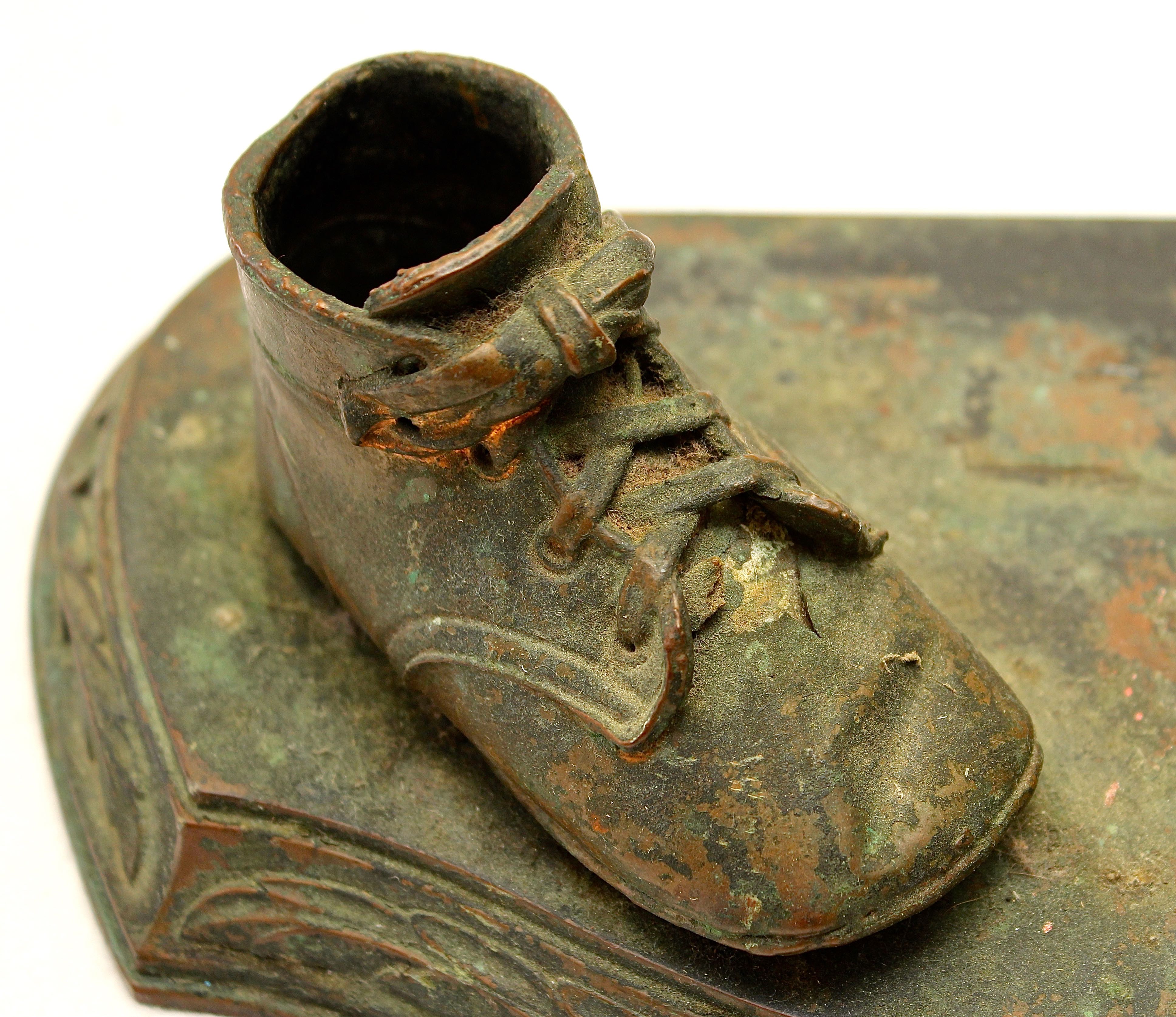 Pair of Vintage Distressed Bronze Look Baby Shoes on a Plinth