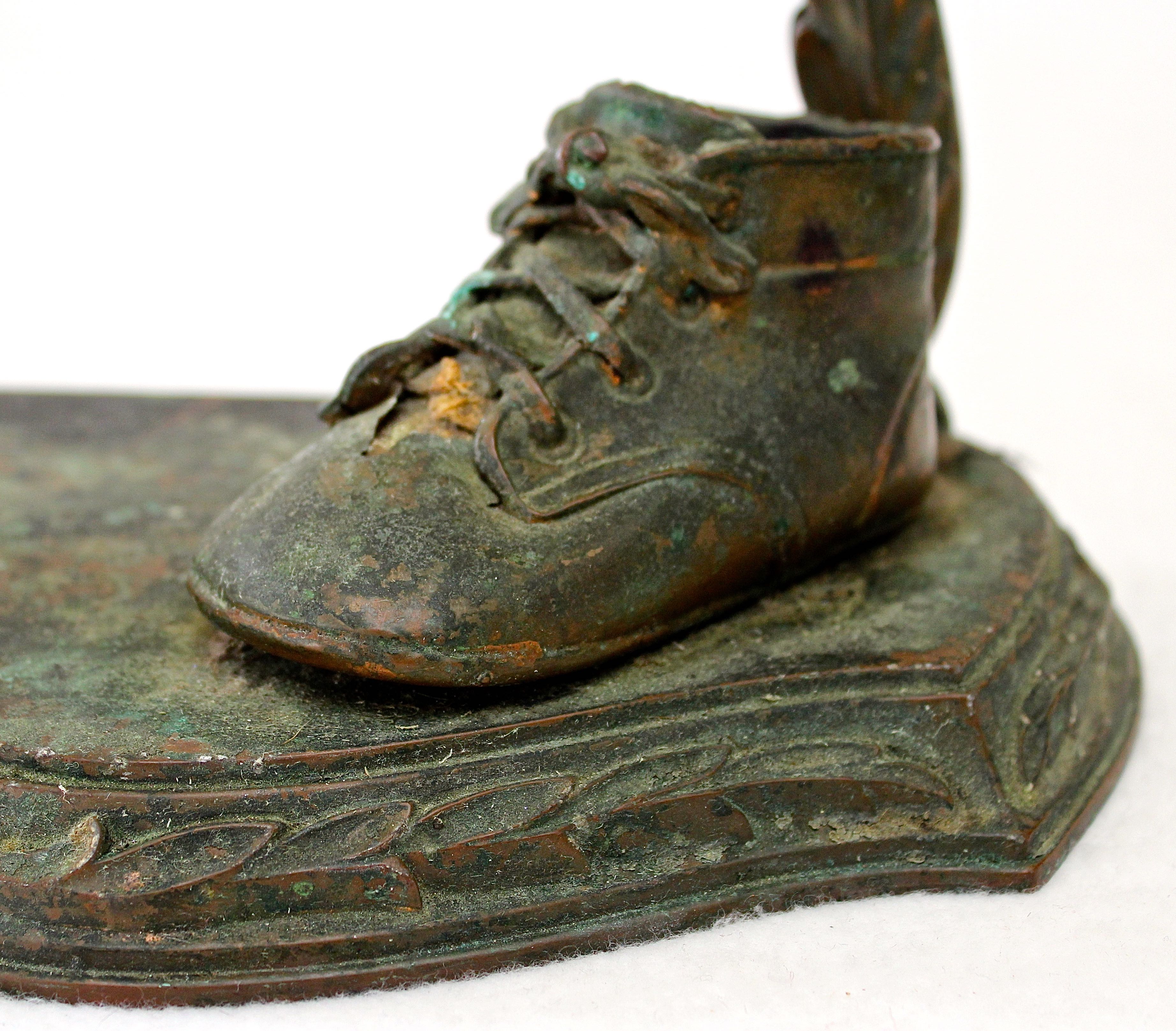 Pair of Vintage Distressed Bronze Look Baby Shoes on a Plinth