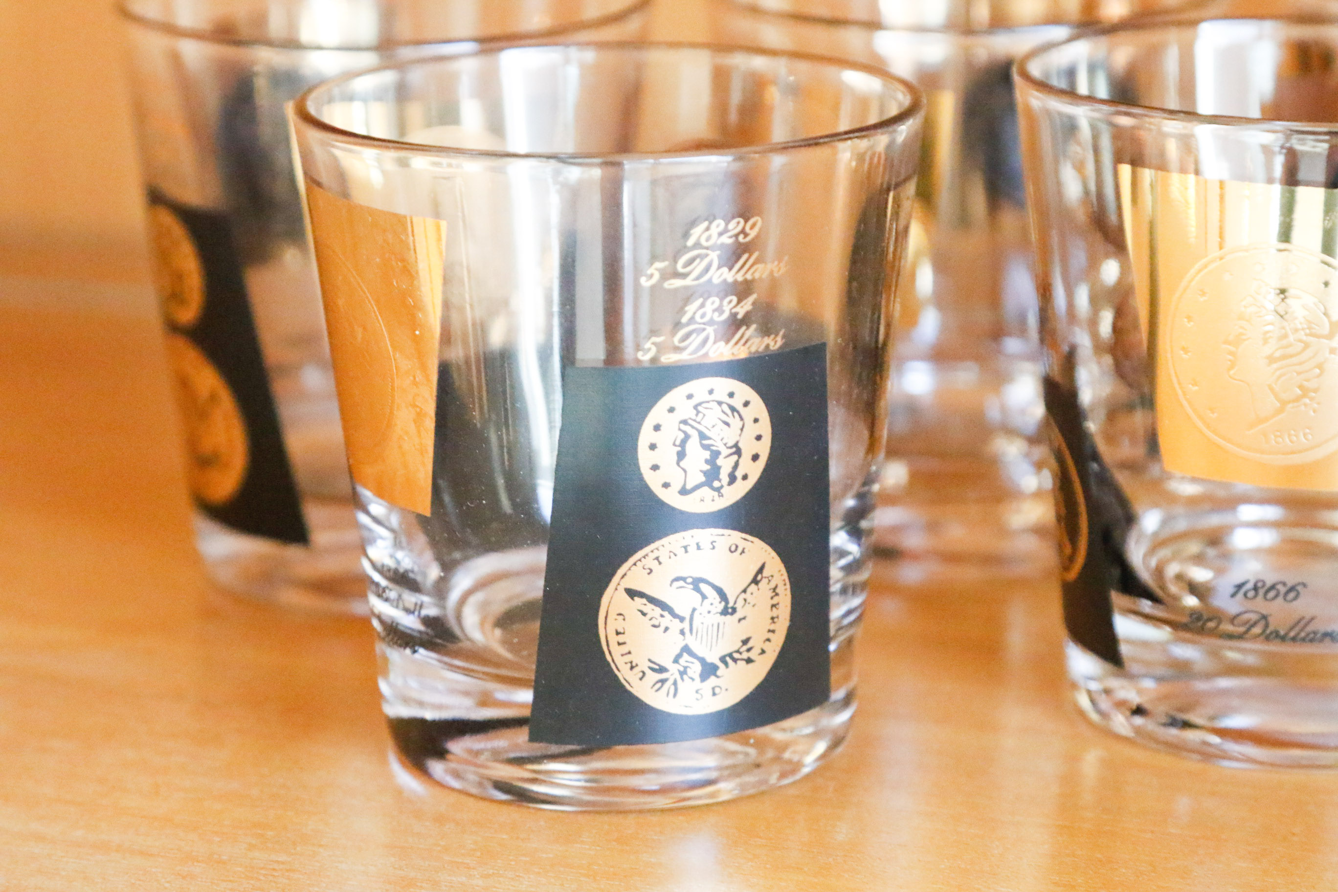 Set of Twelve Vintage Black and Gold U.S. Coin Theme Tumblers