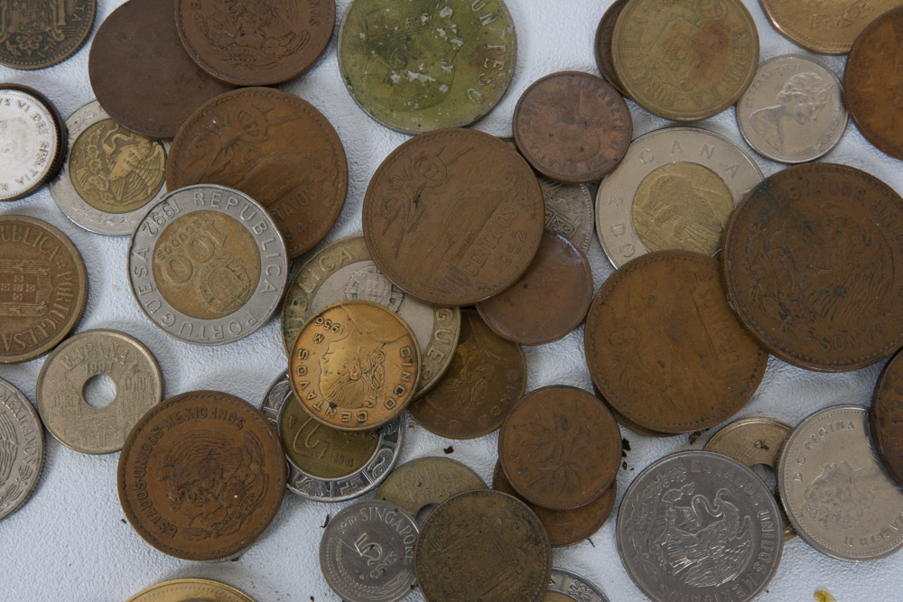 Collection of Mexican and Canadian Coins in a Glass Vase