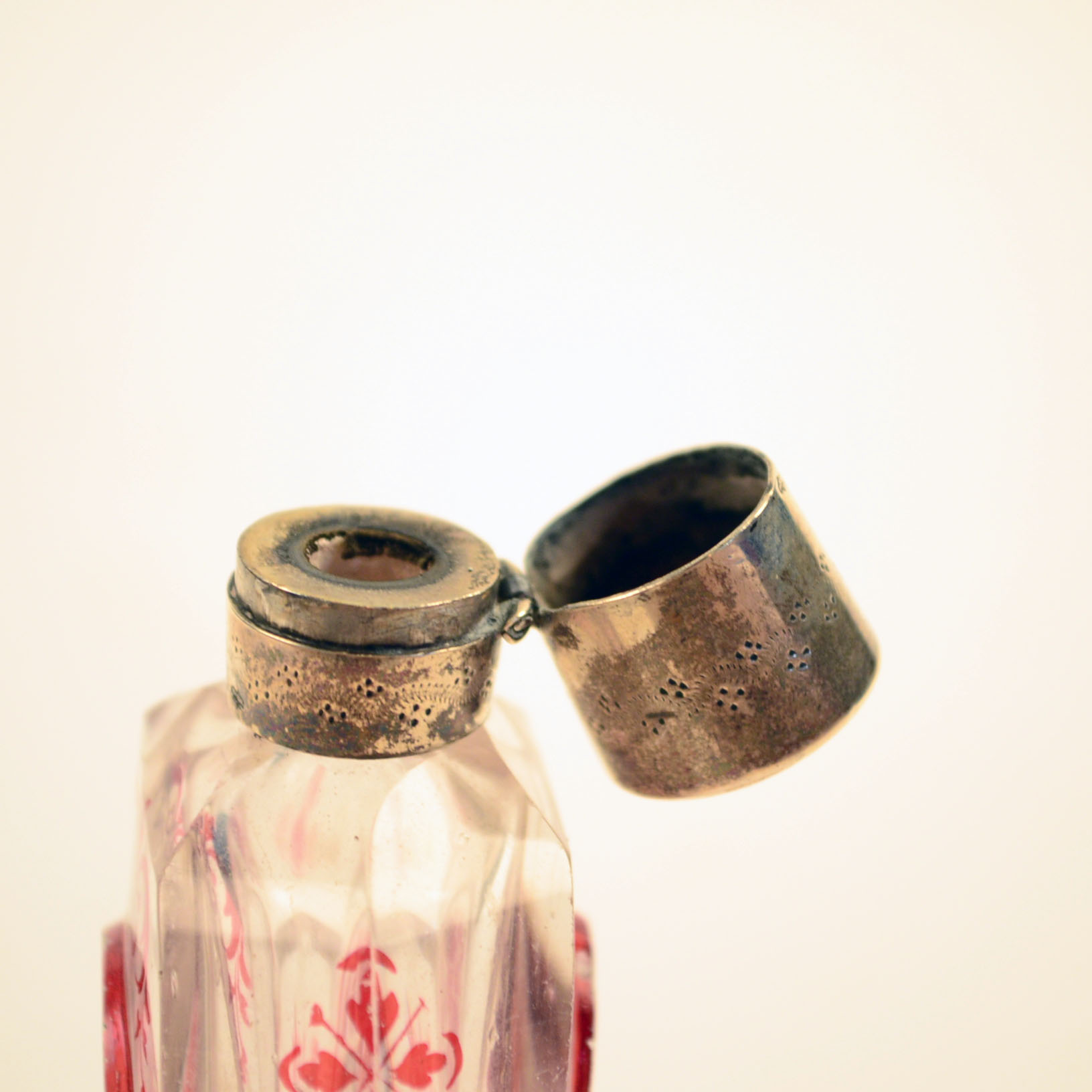 Antique Glass Perfume Bottle with Red Accents and Metal Cap