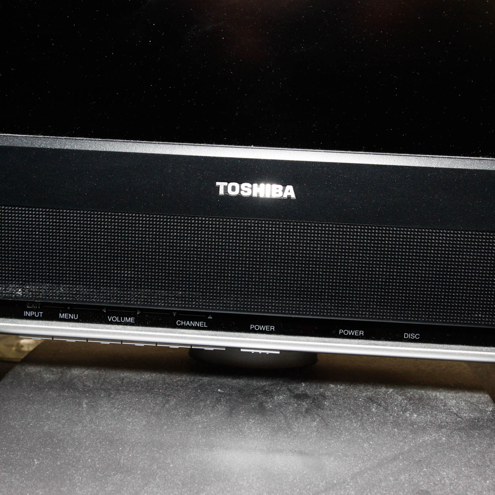 Toshiba Flat Screen Television Mounted on Black Two Shelf Cabinet