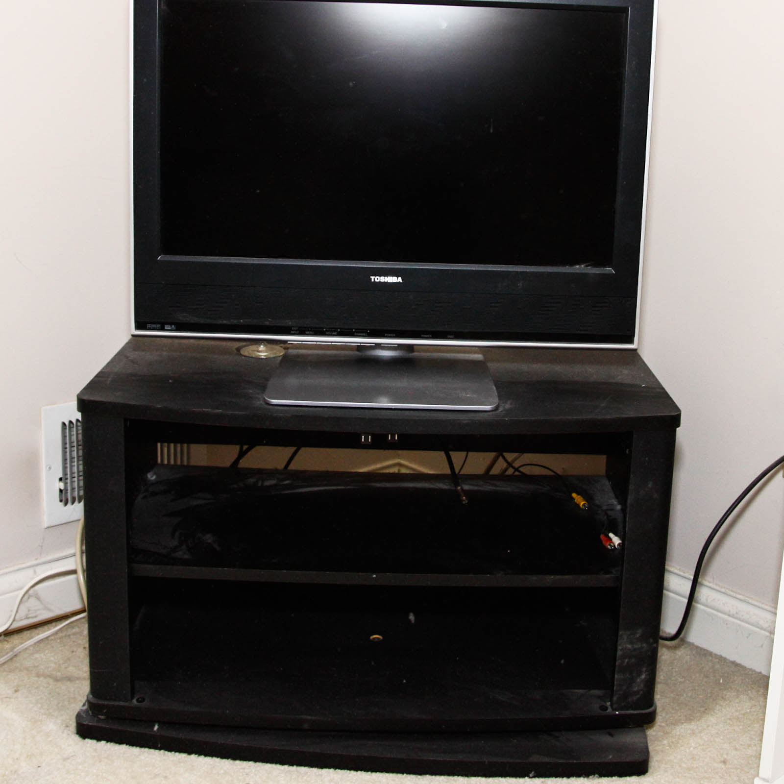 Toshiba Flat Screen Television Mounted on Black Two Shelf Cabinet