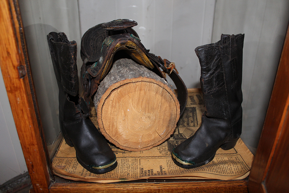 Antique Display Case Containing Children's Boots and Saddle