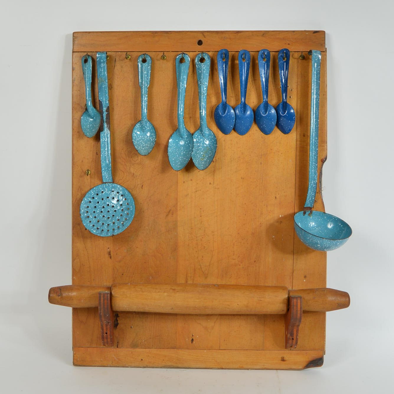 Collection of Speckled Enamel Ware Utensils Mounted on a Cutting Board