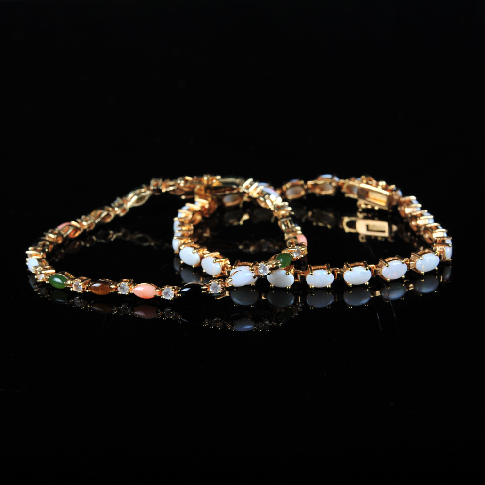 Pair of Gold Tone Bracelets Featuring Imitation Diamonds and Gemstones