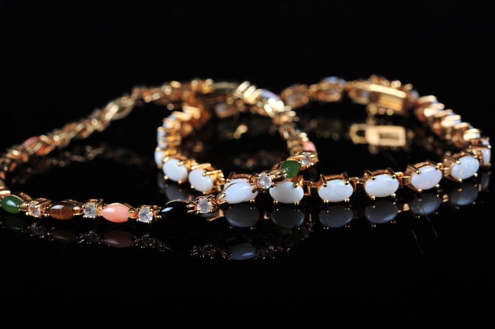 Pair of Gold Tone Bracelets Featuring Imitation Diamonds and Gemstones