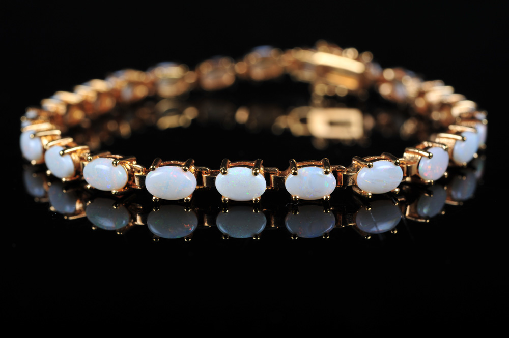 Pair of Gold Tone Bracelets Featuring Imitation Diamonds and Gemstones