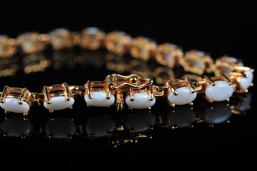 Pair of Gold Tone Bracelets Featuring Imitation Diamonds and Gemstones