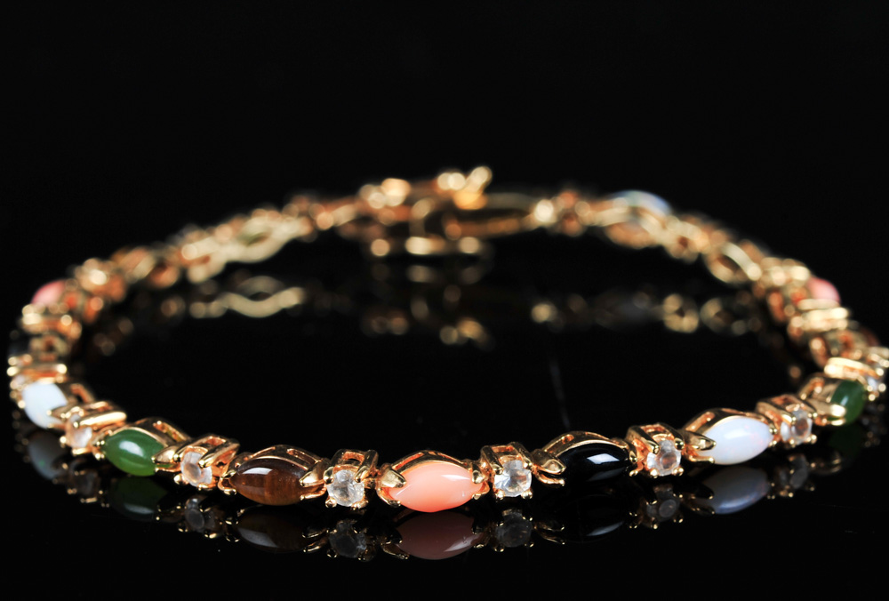 Pair of Gold Tone Bracelets Featuring Imitation Diamonds and Gemstones