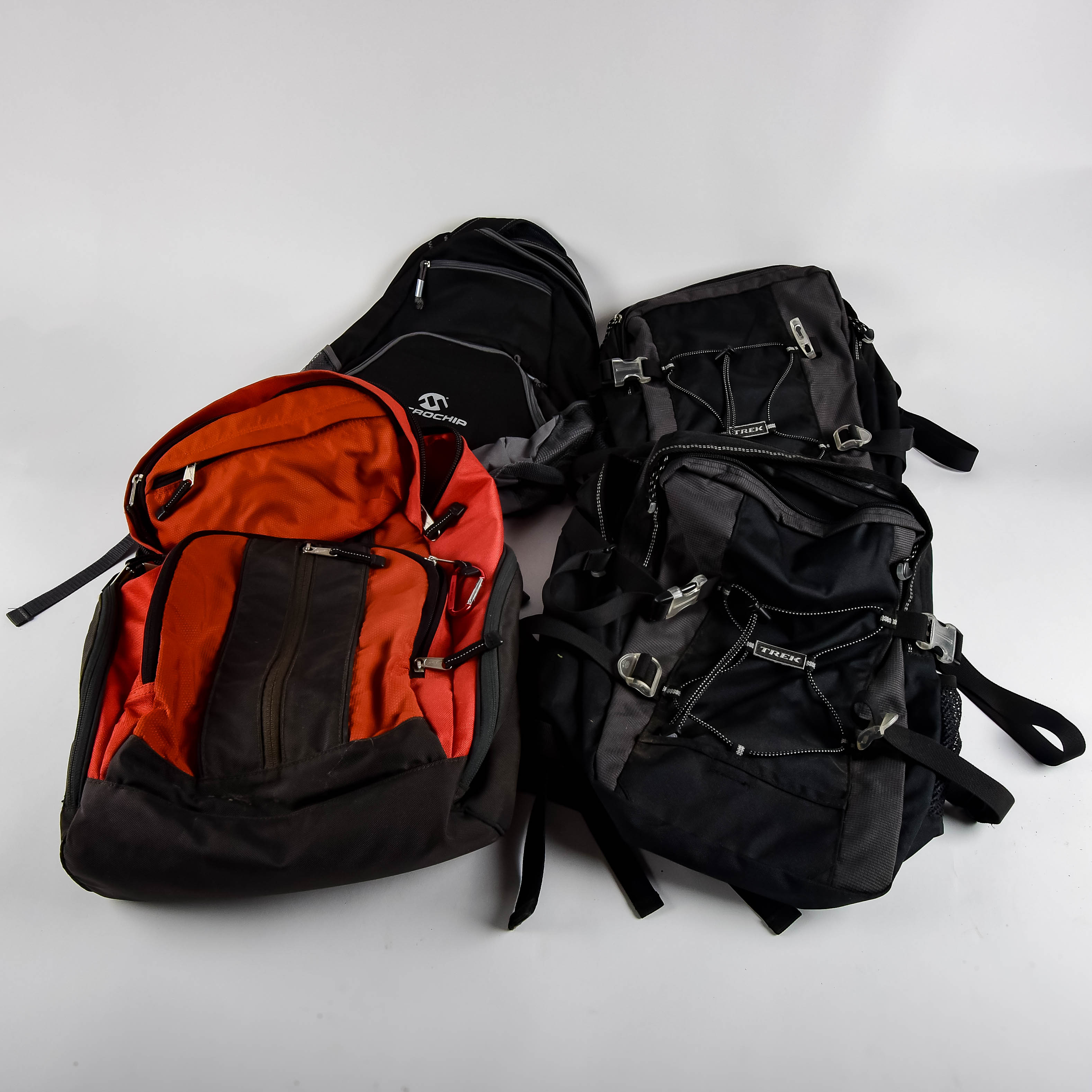 Four Black and Red Backpacks Including Trek