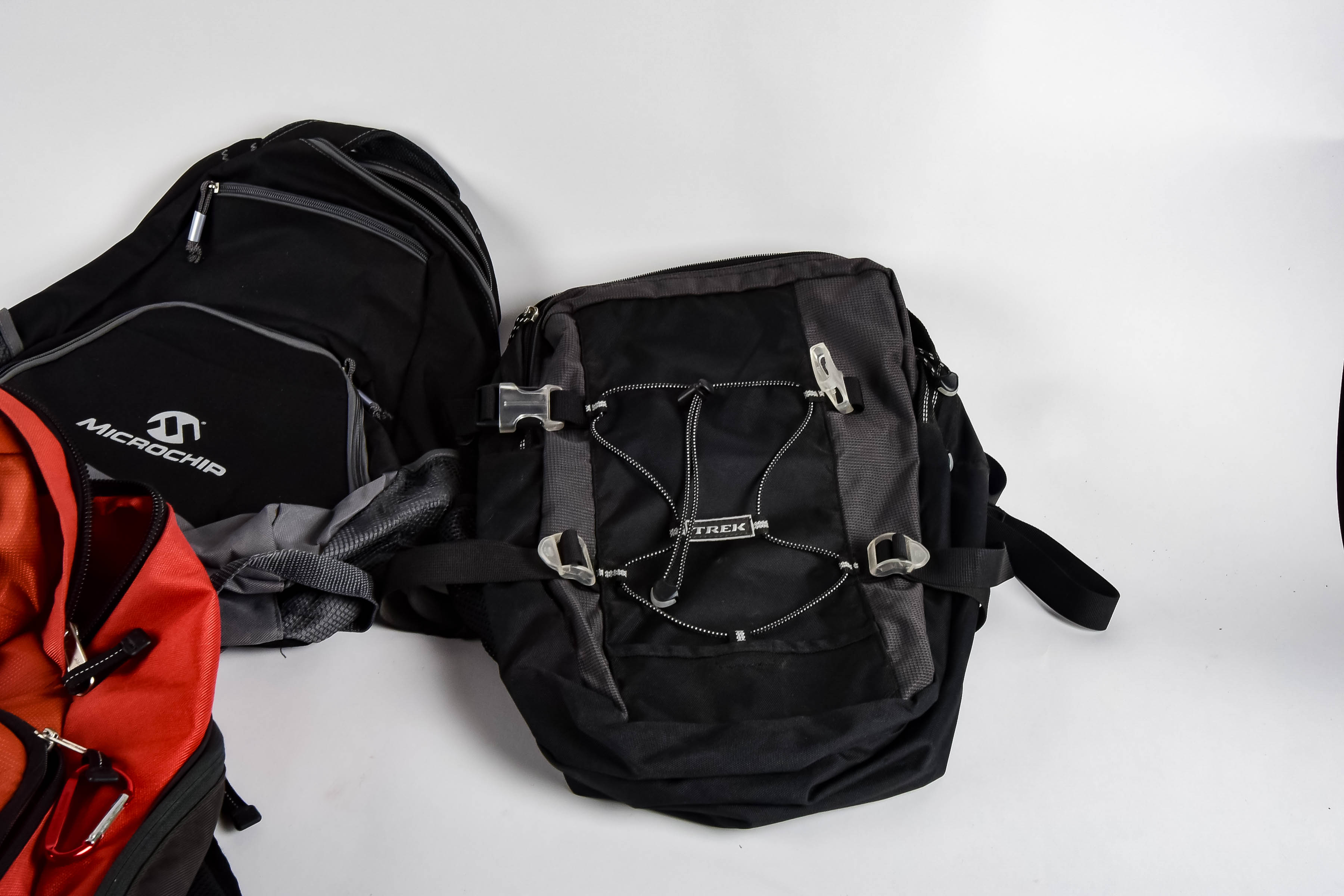 Four Black and Red Backpacks Including Trek