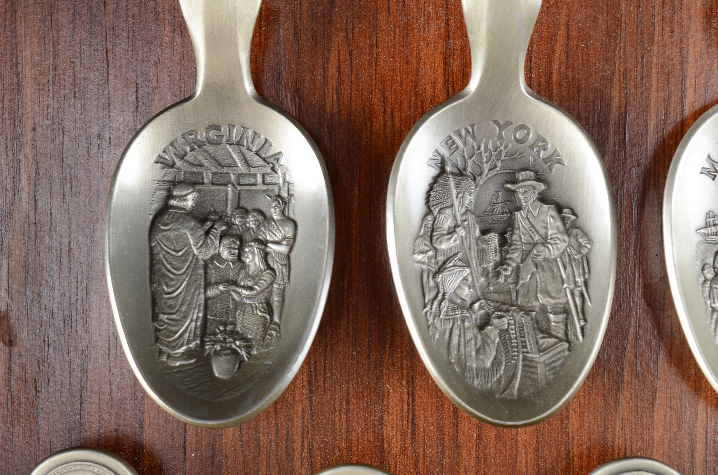 Collection of Thirteen Original State Spoons Displayed in Wooden Shelf