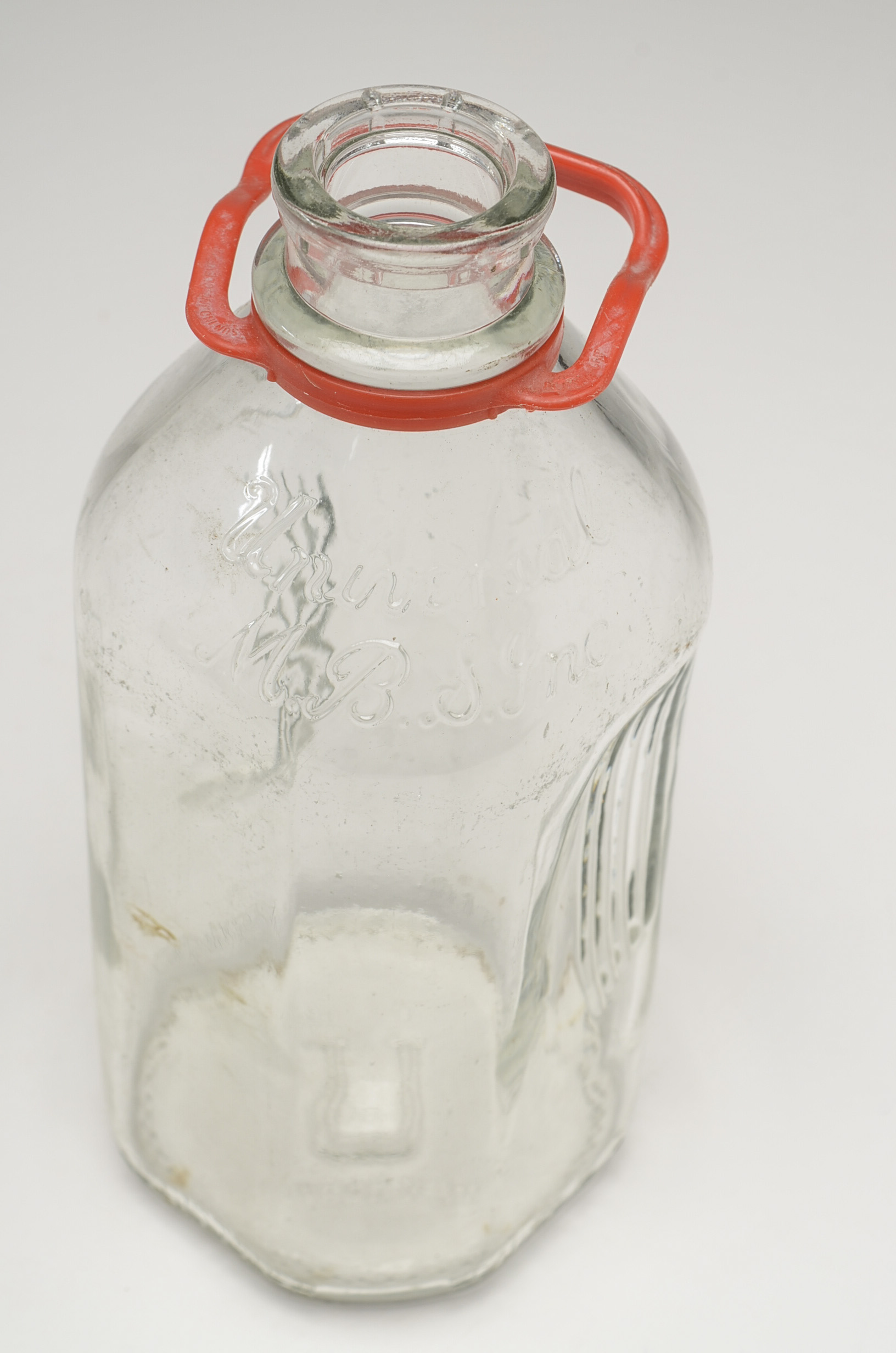 A Set of Four Universal M. B. S. Inc. Half Gallon Milk Bottles with a Wire Carrier