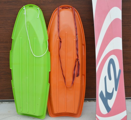 K2 Fat Bob Snow Board and Two Plastic Sleds