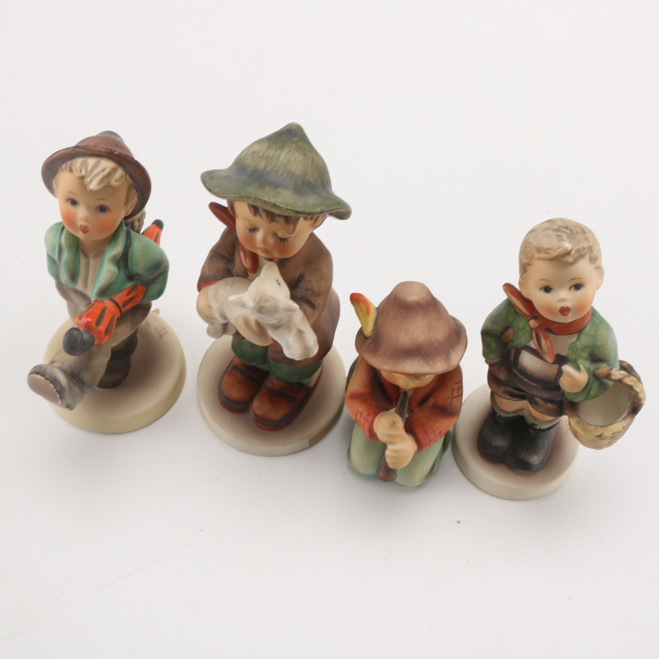 Goebel Hummels "Little Tooter", "Village Boy", "Globe Trotter", and "Lost Sheep"