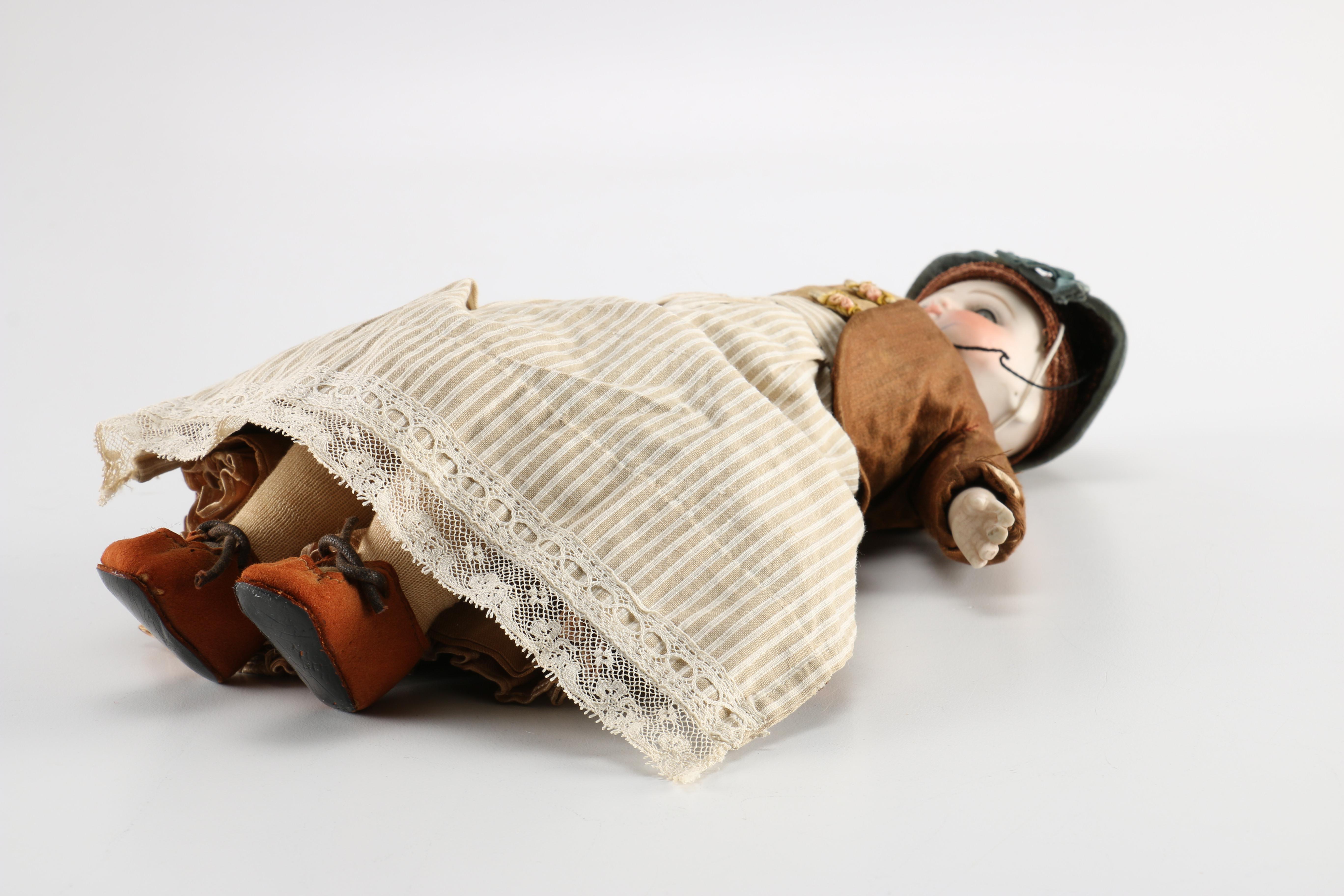 Antique Hand-Painted Bisque Doll With Inset Eyes and Leather Body