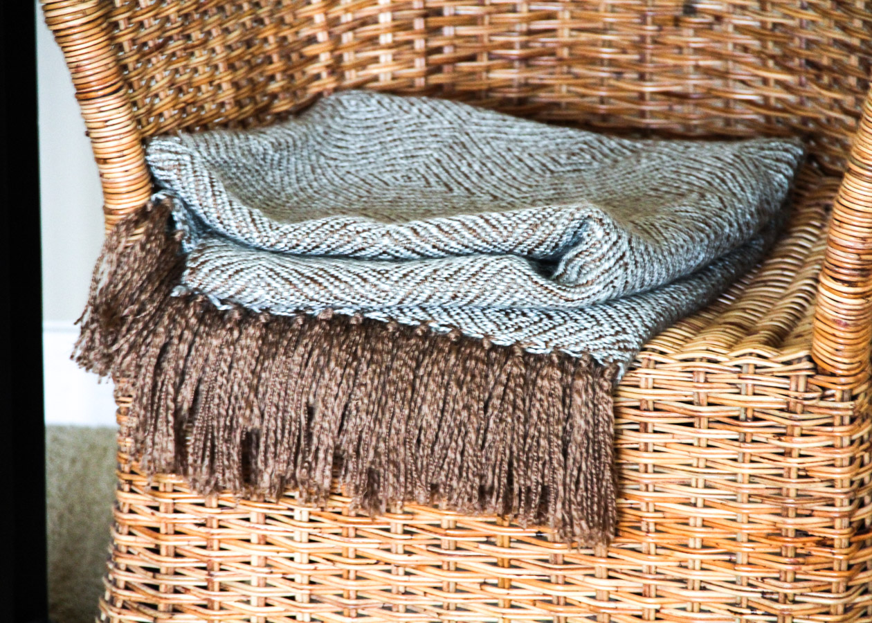 Wicker Chair with Side Table, Throw, and Votive