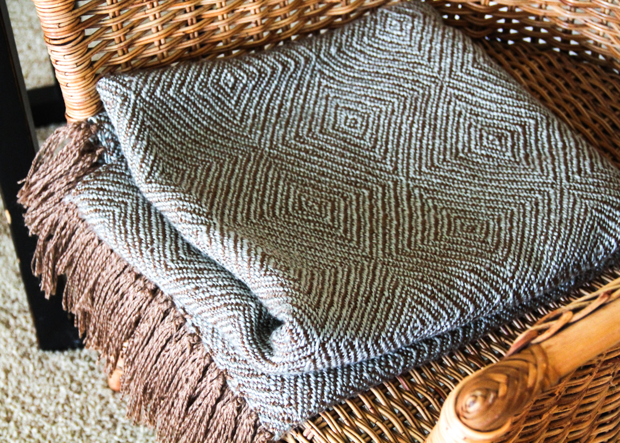 Wicker Chair with Side Table, Throw, and Votive