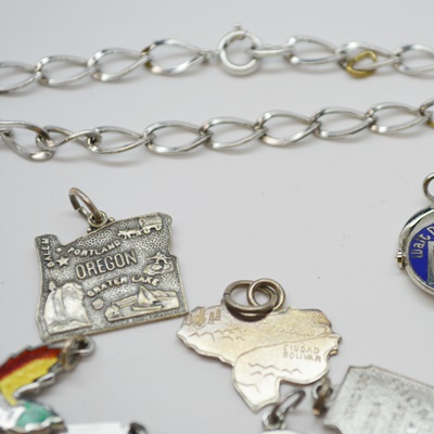 Eleven Sterling Silver Travel Charms and Charm Bracelet
