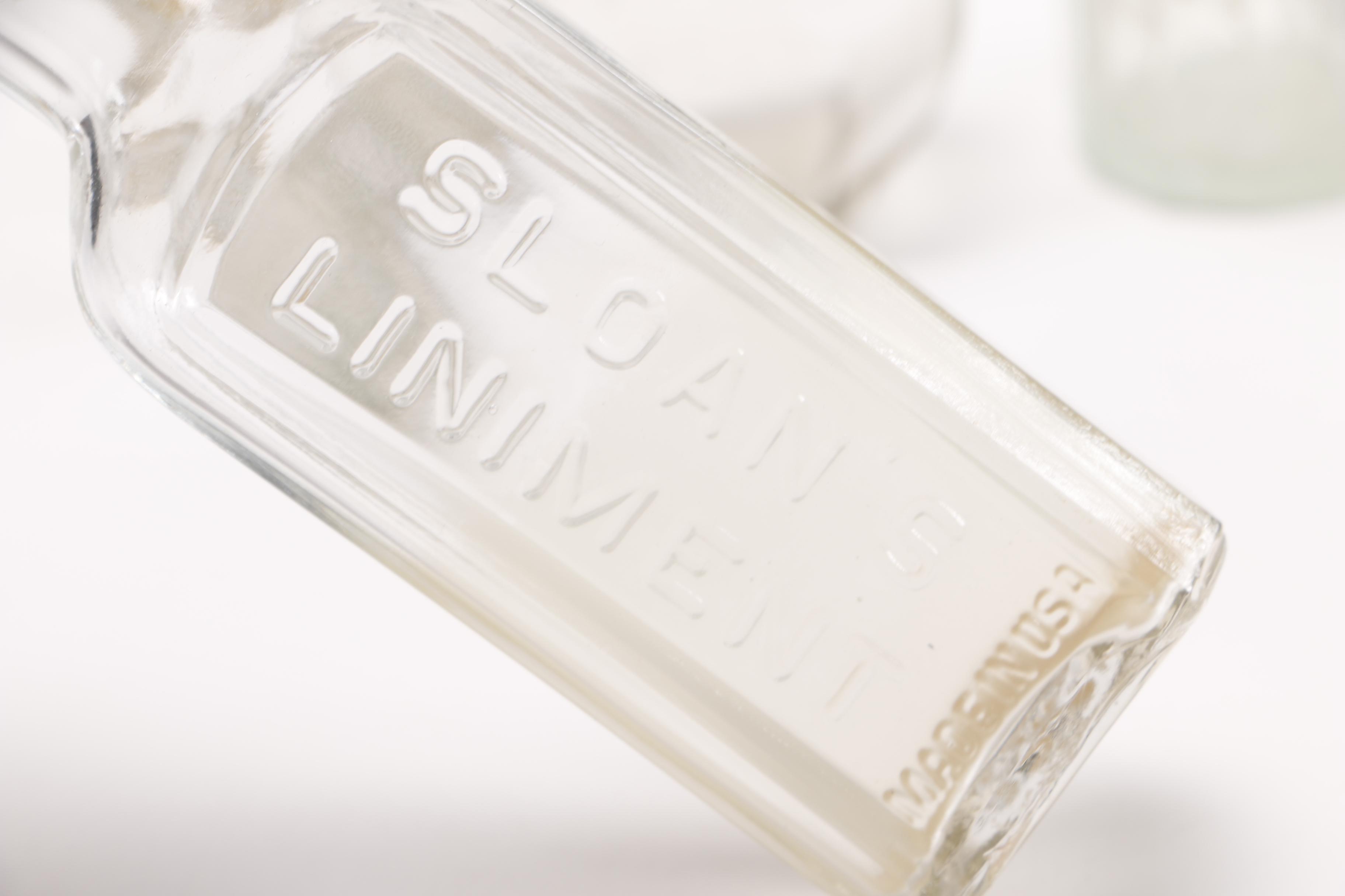 Vintage Glass Bottles Including Coca-Cola, Sloan's Liniment and Three Feathers Whiskey