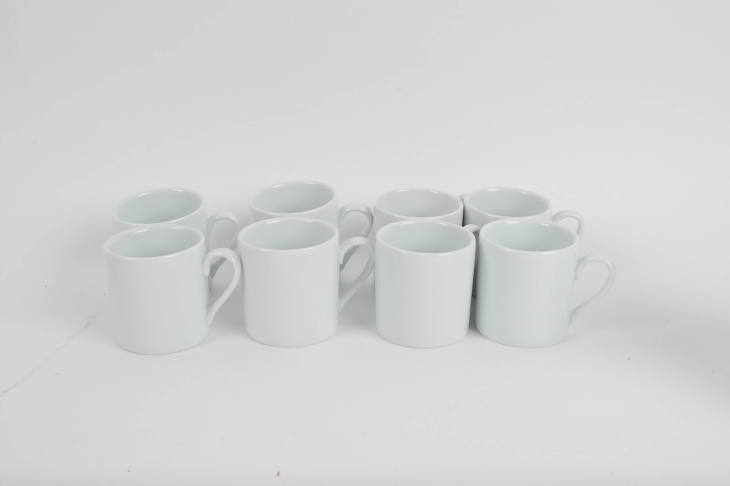 Set of Eight White Glazed Demitasse Cups and Saucers