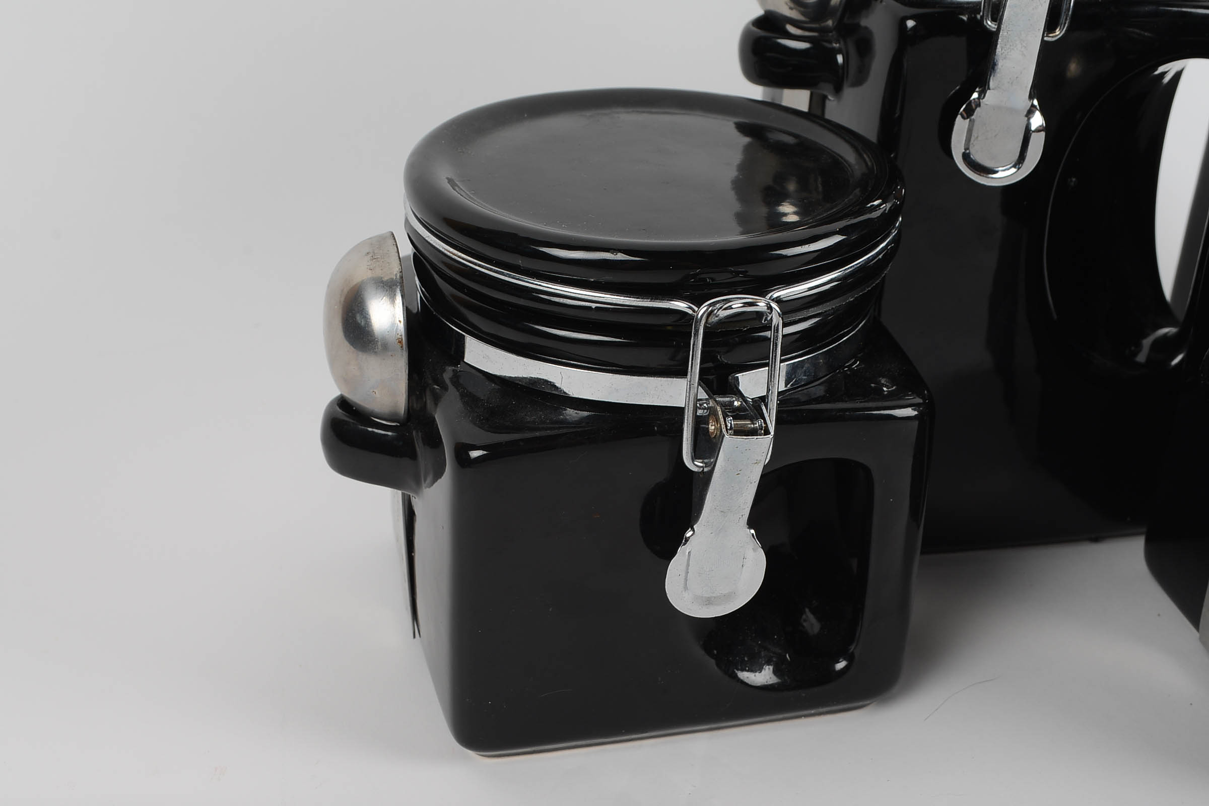 A Set of Covered Black Ceramic Kitchen Canisters