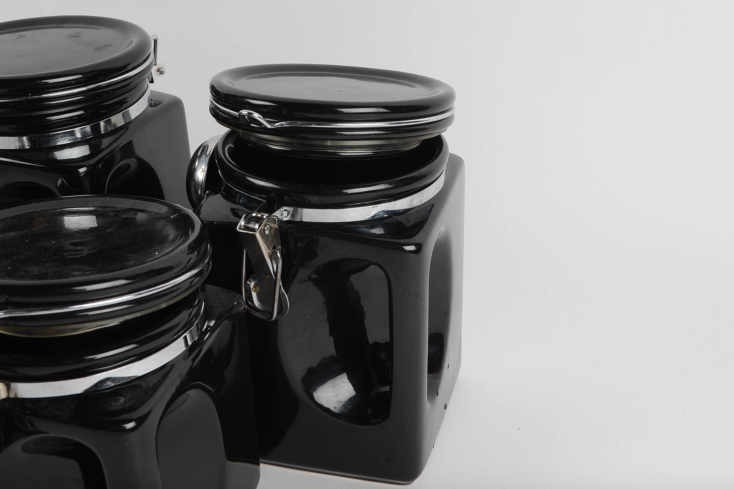 A Set of Covered Black Ceramic Kitchen Canisters