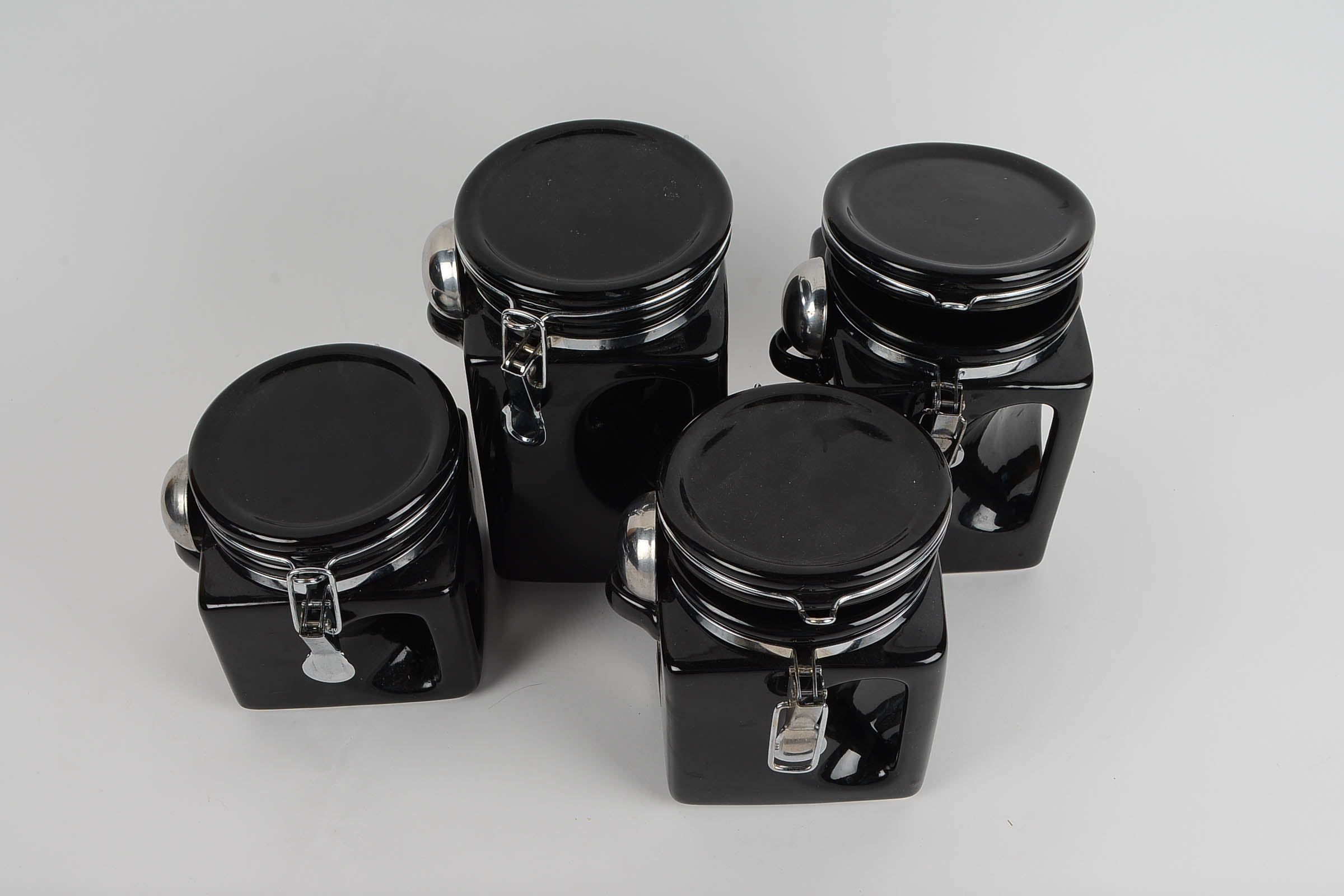 A Set of Covered Black Ceramic Kitchen Canisters