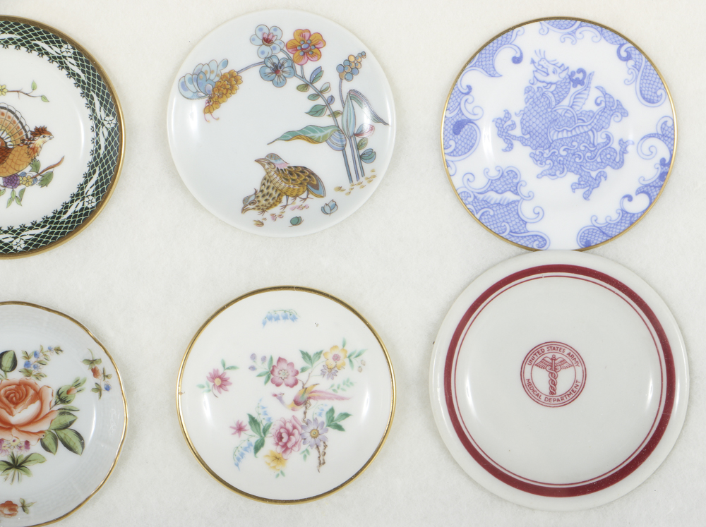 Twelve Porcelain Butter Pats In Glass Top Display Case