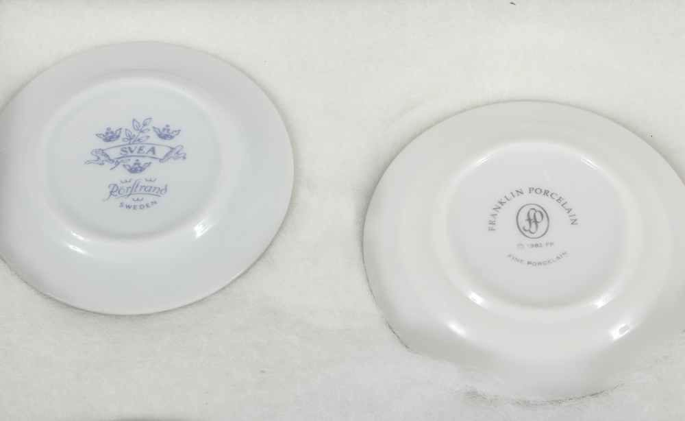 Twelve Porcelain Butter Pats In Glass Top Display Case