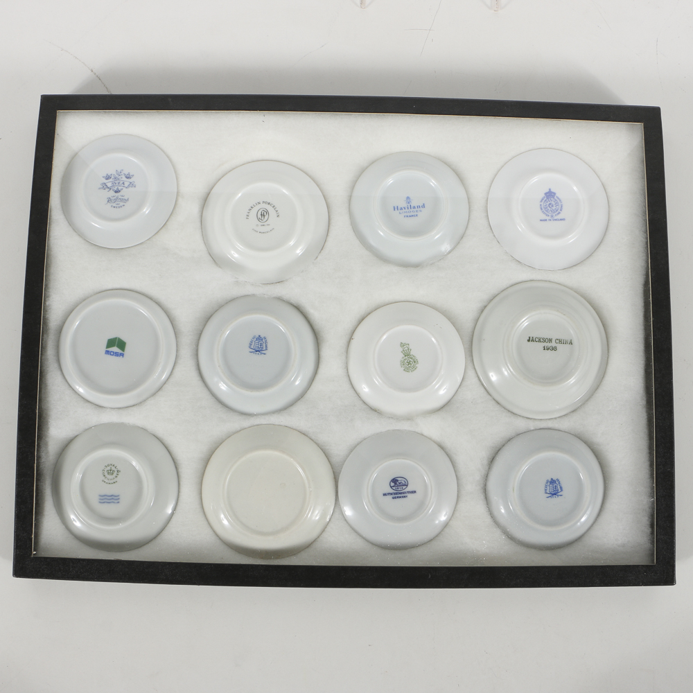 Twelve Porcelain Butter Pats In Glass Top Display Case