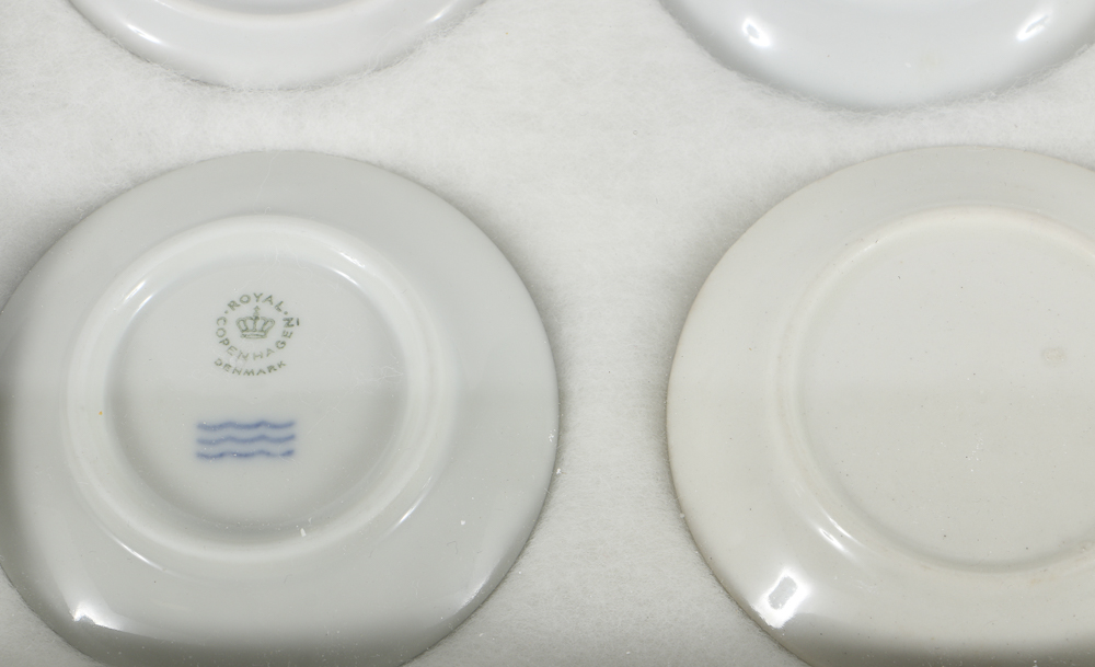 Twelve Porcelain Butter Pats In Glass Top Display Case