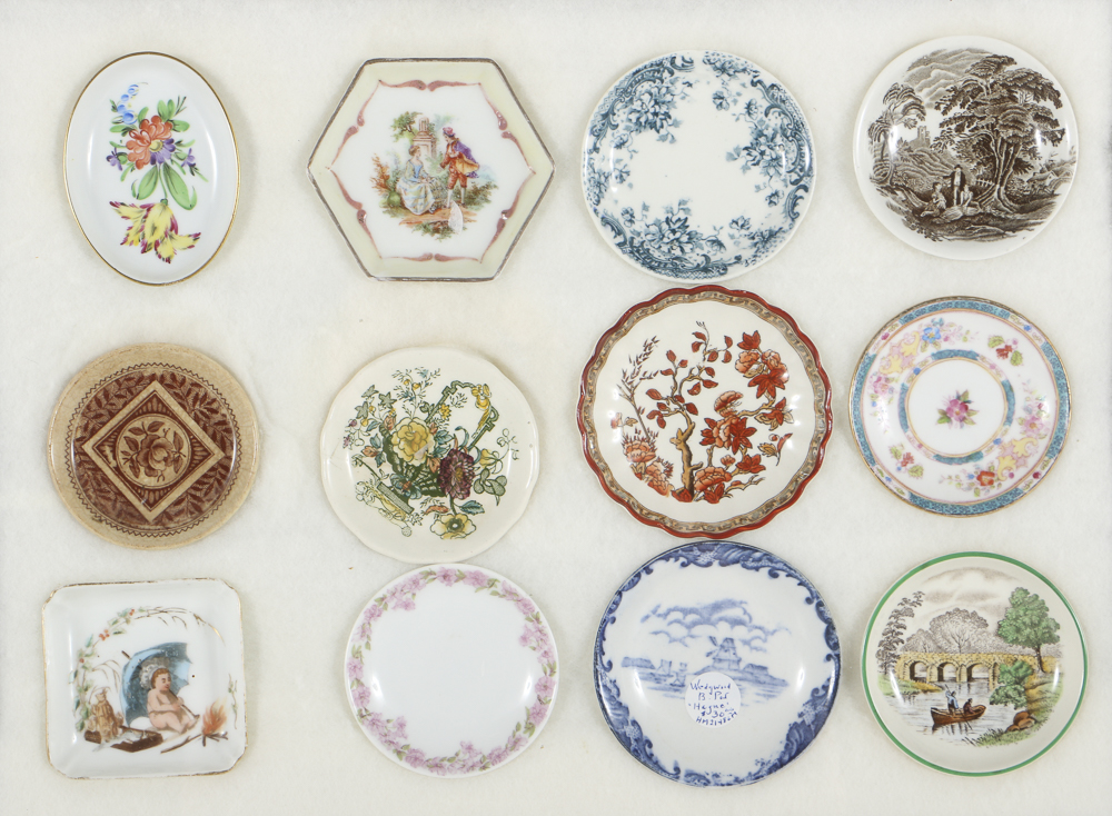 Twelve Porcelain Butter Pats In Glass Top Display Case