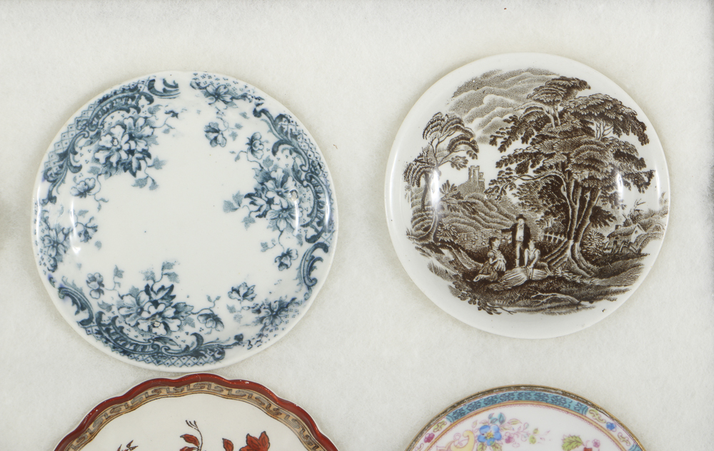 Twelve Porcelain Butter Pats In Glass Top Display Case