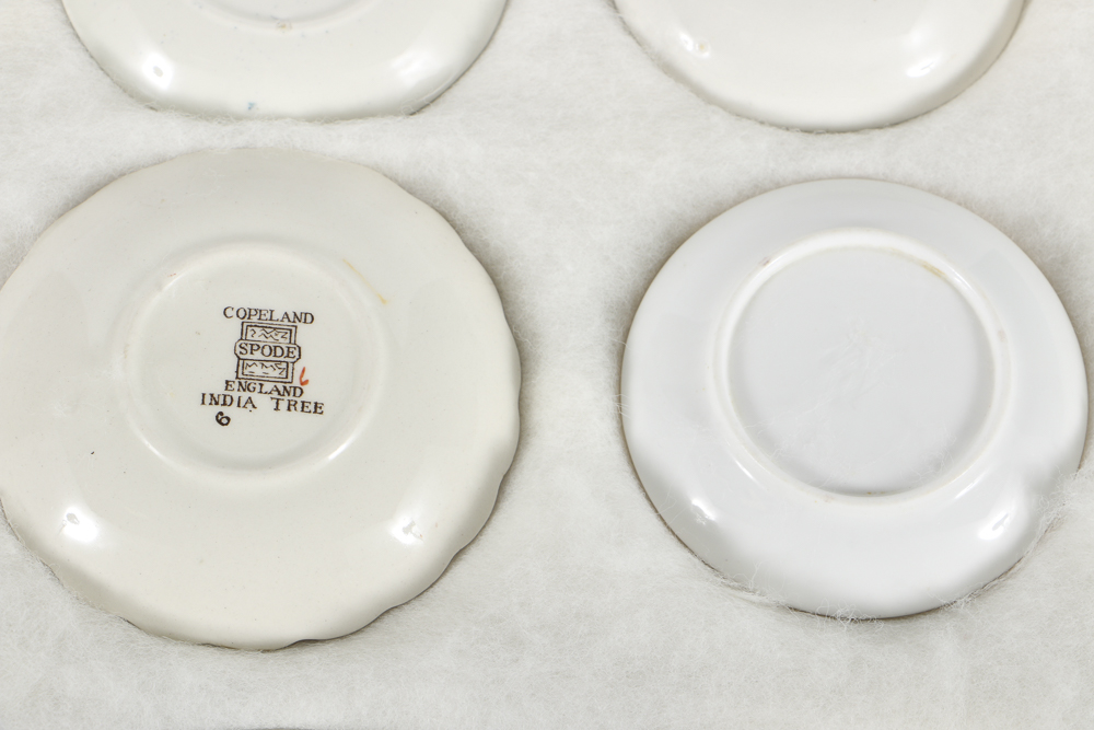 Twelve Porcelain Butter Pats In Glass Top Display Case