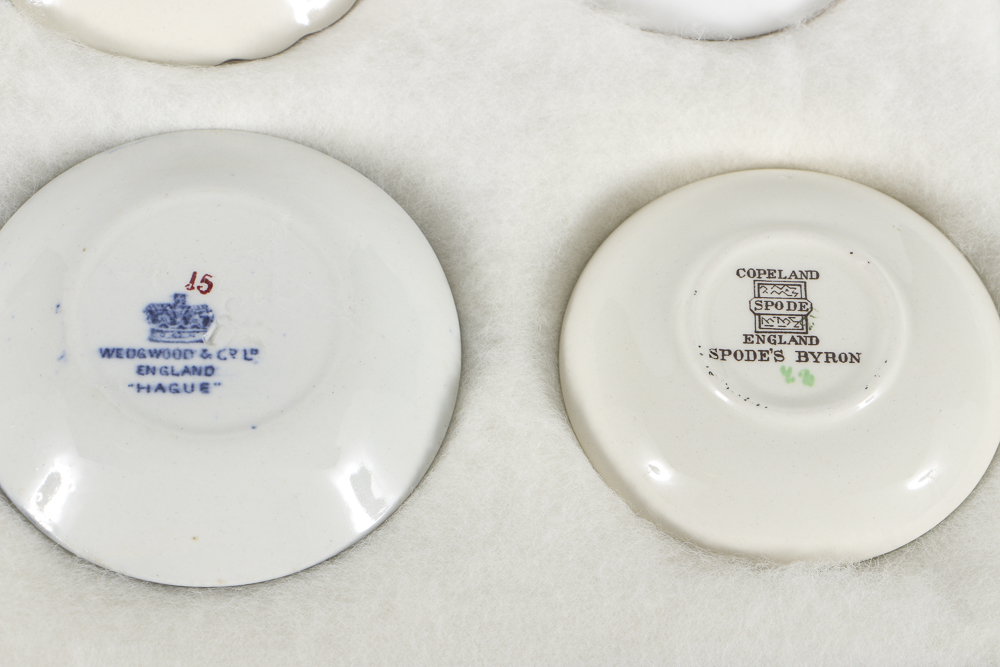 Twelve Porcelain Butter Pats In Glass Top Display Case