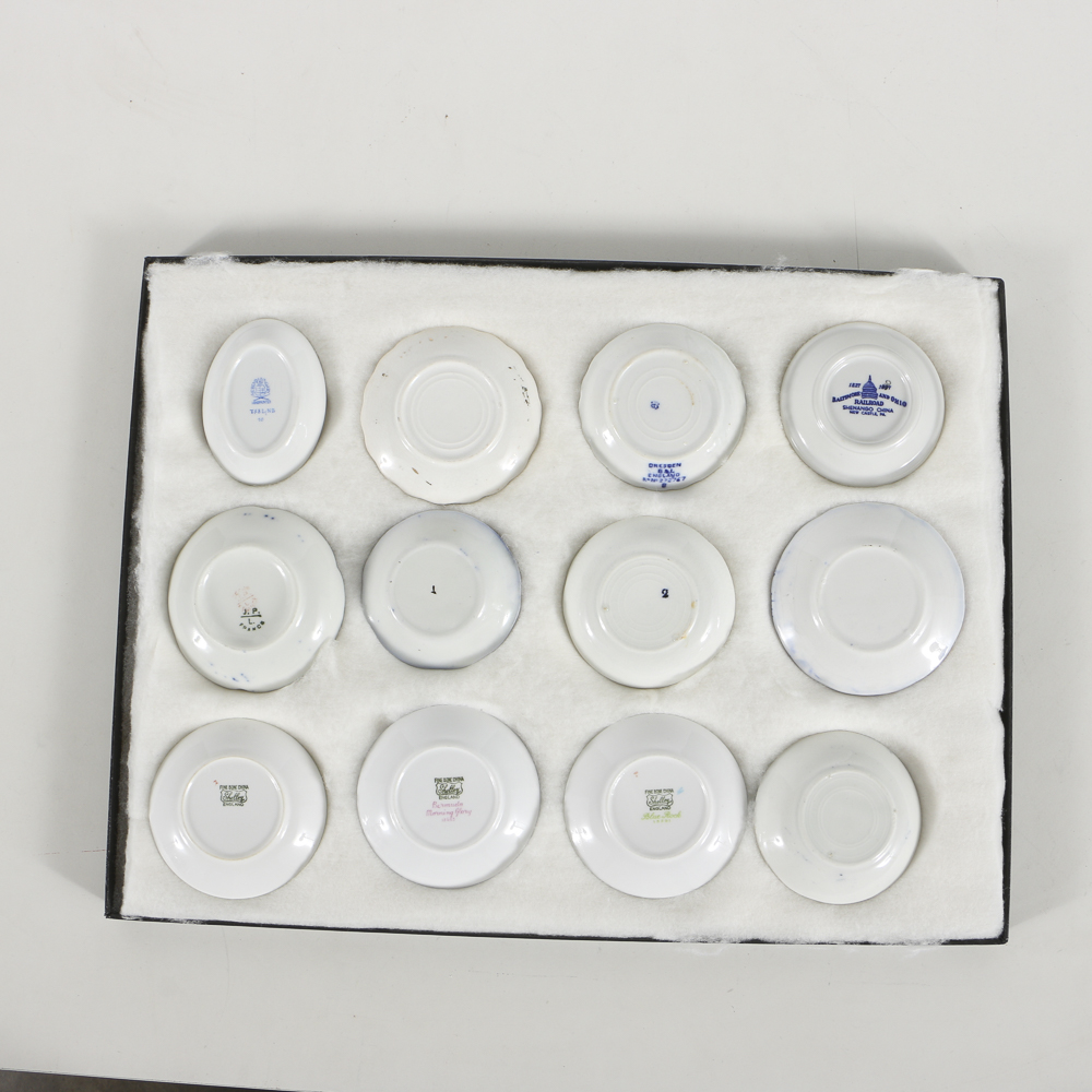 Twelve Porcelain Butter Pats In Glass Top Display Case