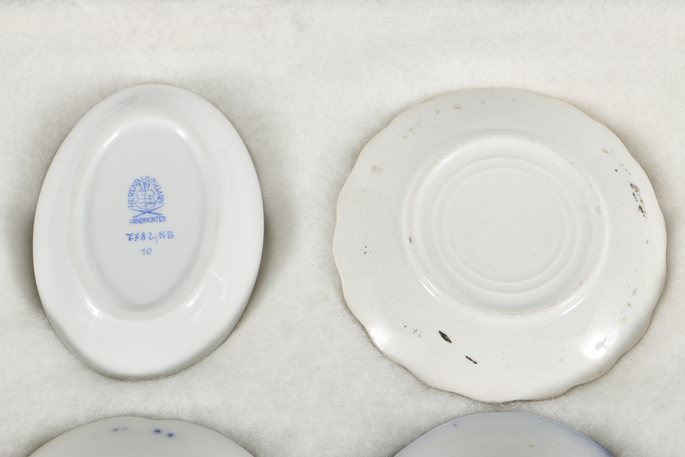 Twelve Porcelain Butter Pats In Glass Top Display Case